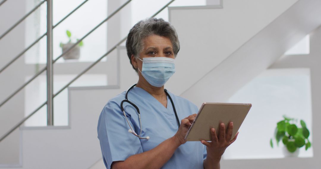 Senior Healthcare Worker Using Digital Tablet in Modern Hospital - Free Images, Stock Photos and Pictures on Pikwizard.com