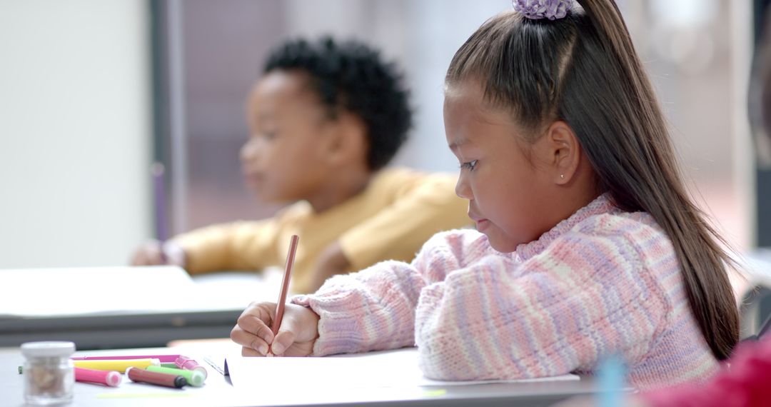 Focused Young Girl Writing in Classroom Setting