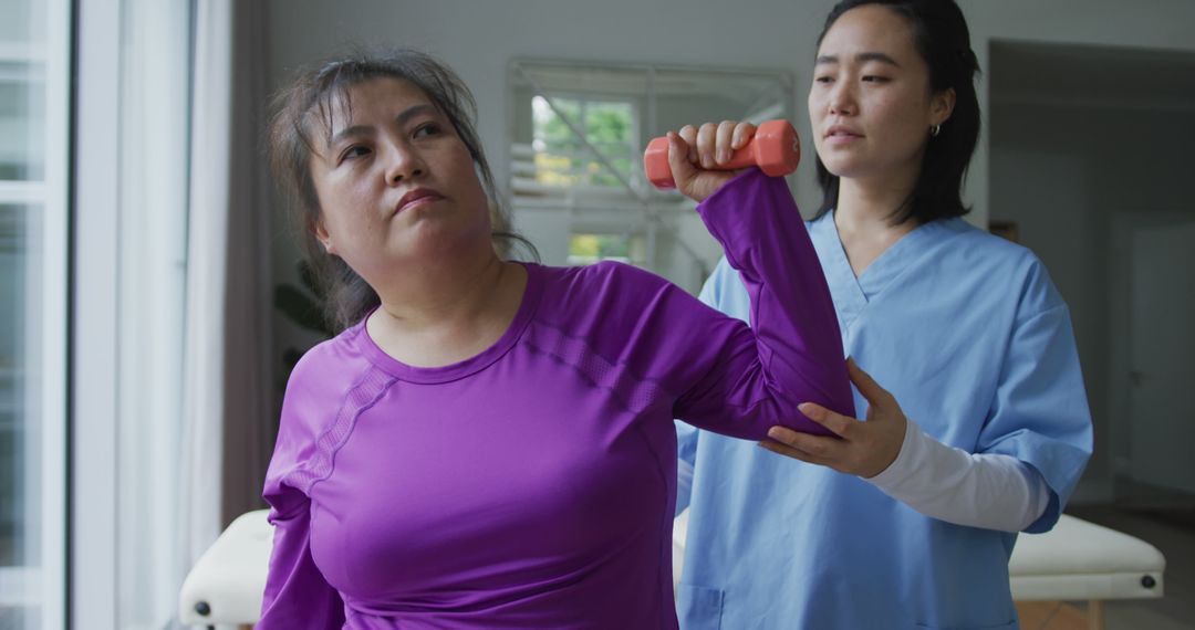 Physical Therapist Assisting Female Patient with Arm Exercise - Free Images, Stock Photos and Pictures on Pikwizard.com