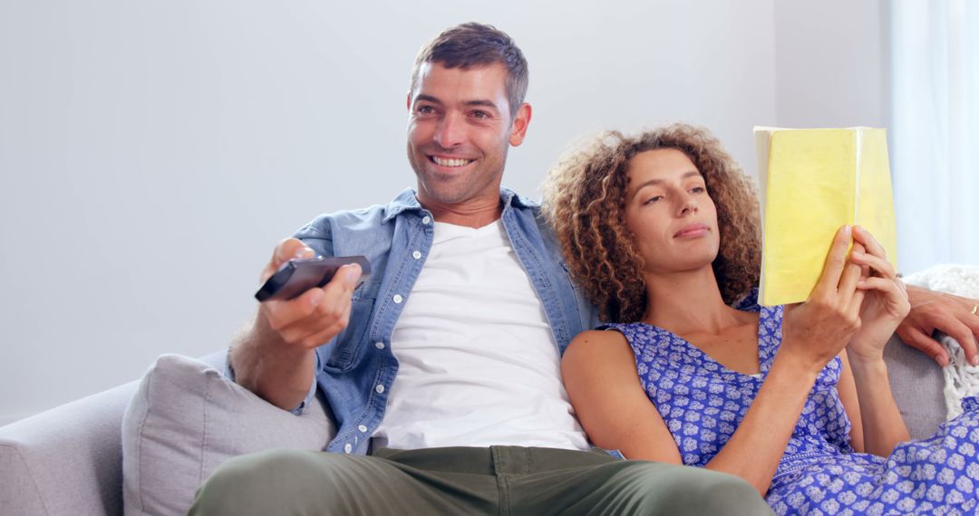 Couple Relaxing at Home, Man Watching TV, Woman Reading - Free Images, Stock Photos and Pictures on Pikwizard.com