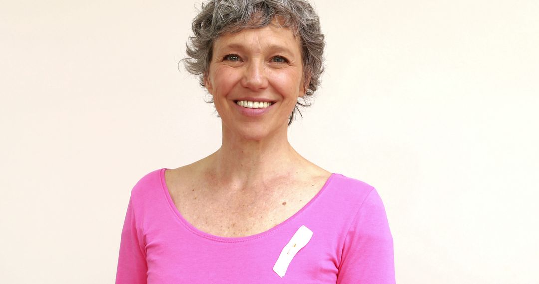 Mature Woman Smiling in Pink Ribbon T-Shirt Promoting Breast Cancer Awareness - Free Images, Stock Photos and Pictures on Pikwizard.com