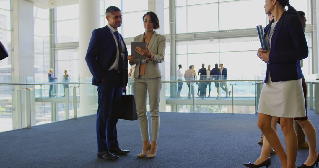 Modern Business Executives Discussing Digital Strategy in Office Lobby