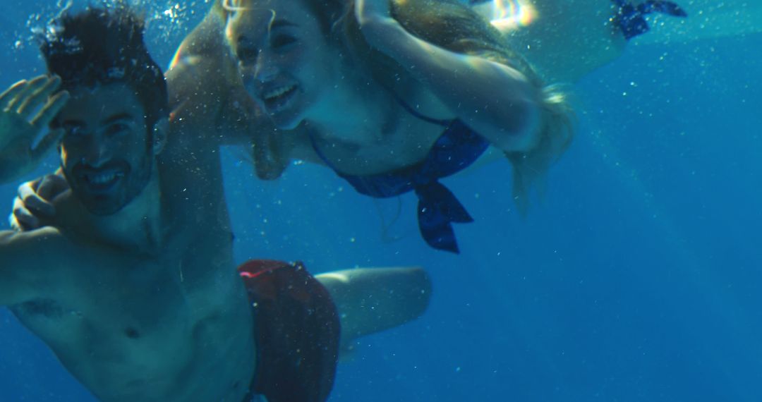 Happy Couple Swimming Underwater in Pool - Free Images, Stock Photos and Pictures on Pikwizard.com