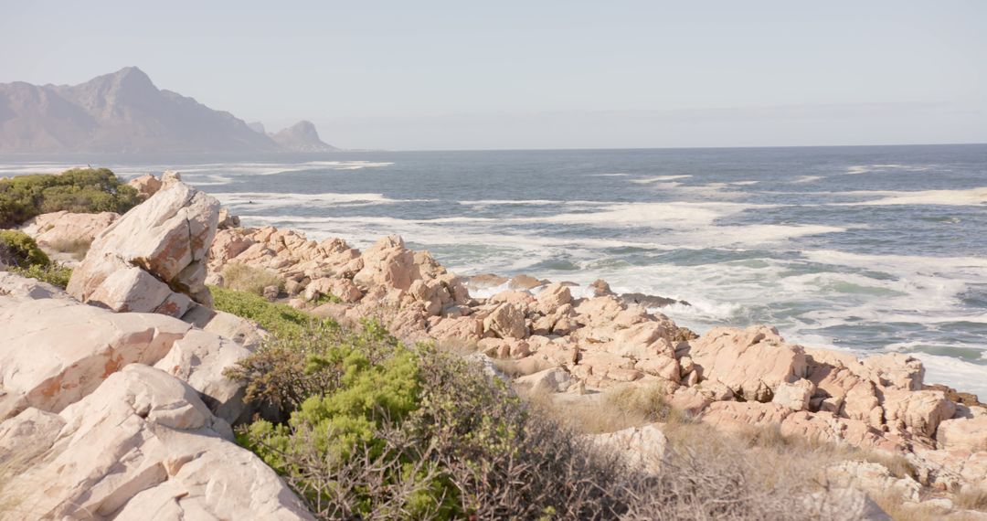 Rocky Coastline with Mountainous Horizon in Daylight - Free Images, Stock Photos and Pictures on Pikwizard.com