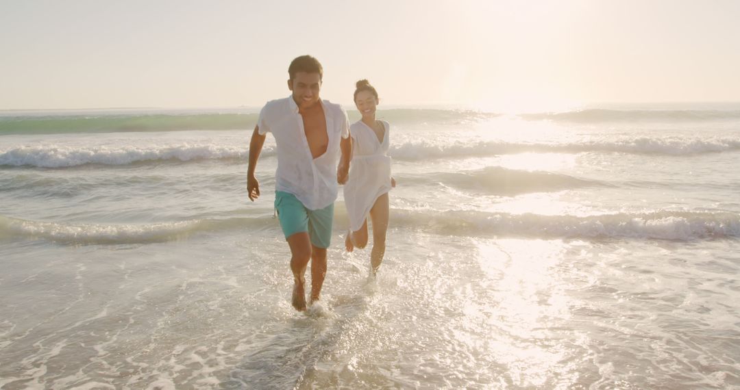 Couple Running and Laughing on Beach at Sunset - Free Images, Stock Photos and Pictures on Pikwizard.com