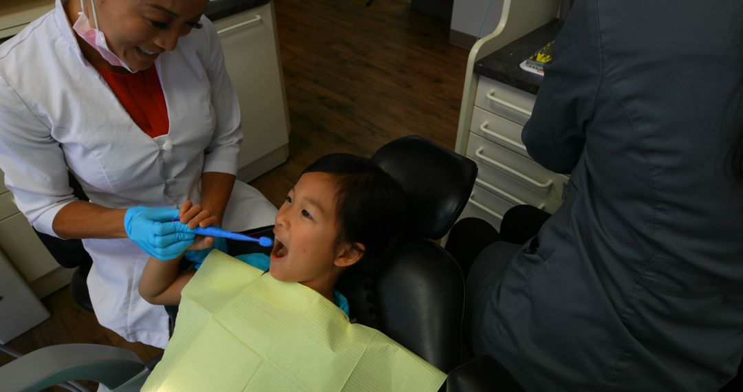 Dentist cleaning child's teeth in clinic - Free Images, Stock Photos and Pictures on Pikwizard.com