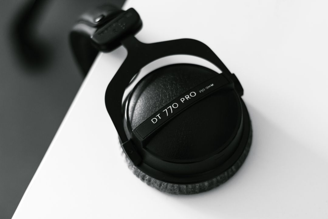 Closeup of Professional Over-Ear Headphones Resting on Table Edge in Monochrome - Free Images, Stock Photos and Pictures on Pikwizard.com