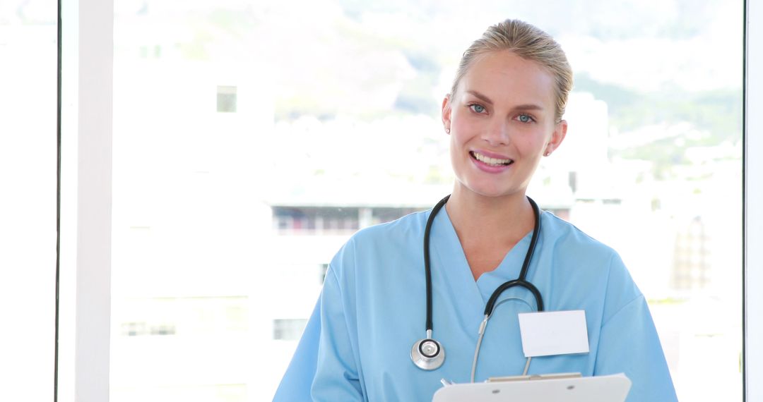 Smiling Female Nurse Holding Clipboard in Bright Medical Office - Free Images, Stock Photos and Pictures on Pikwizard.com