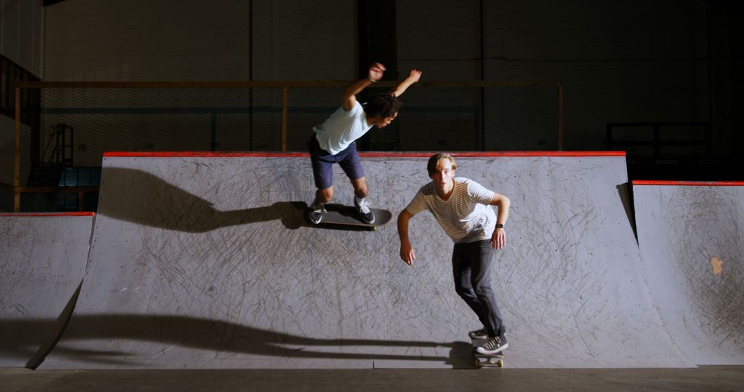 Two skateboarders performing tricks on indoor skate ramp - Free Images, Stock Photos and Pictures on Pikwizard.com