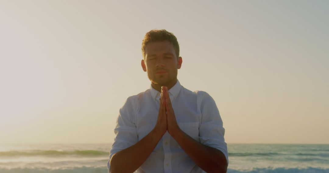 Man Meditating on Beach During Tranquil Sunset