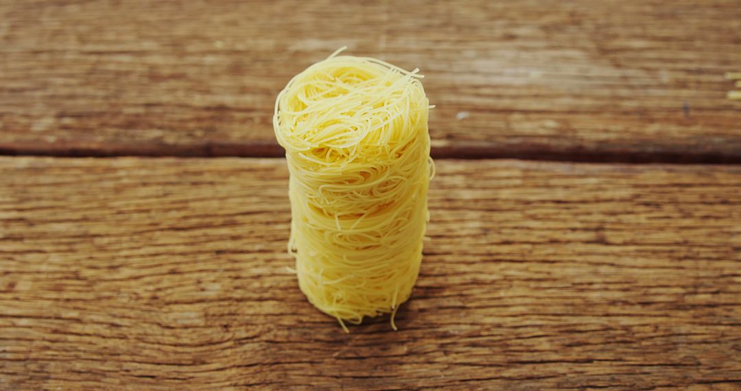 Uncooked Nest of Thin Noodles on Wooden Surface - Free Images, Stock Photos and Pictures on Pikwizard.com