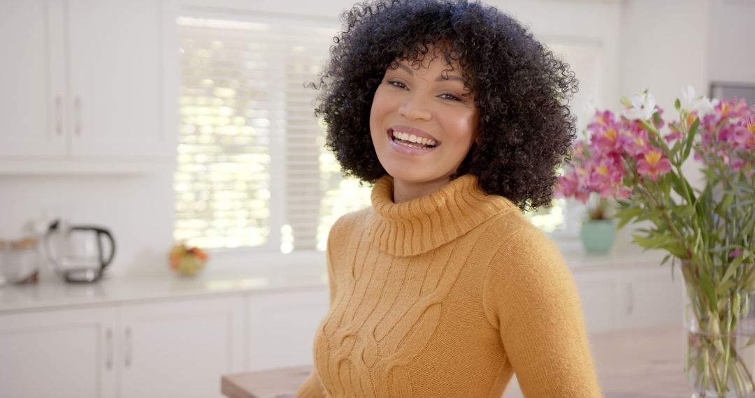 Cheerful Woman Smiling in Sunny Kitchen with Flowers - Free Images, Stock Photos and Pictures on Pikwizard.com