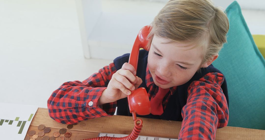 Kid Talking on Red Vintage Phone in Office Atmosphere - Free Images, Stock Photos and Pictures on Pikwizard.com