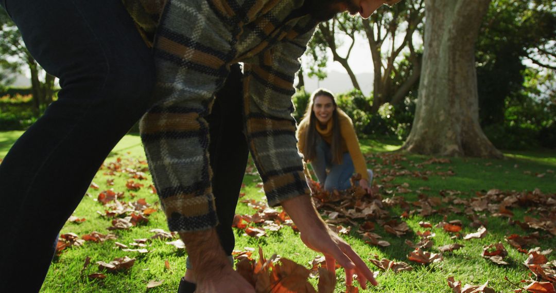 Cheerful Couple Collecting Autumn Leaves in Park - Free Images, Stock Photos and Pictures on Pikwizard.com