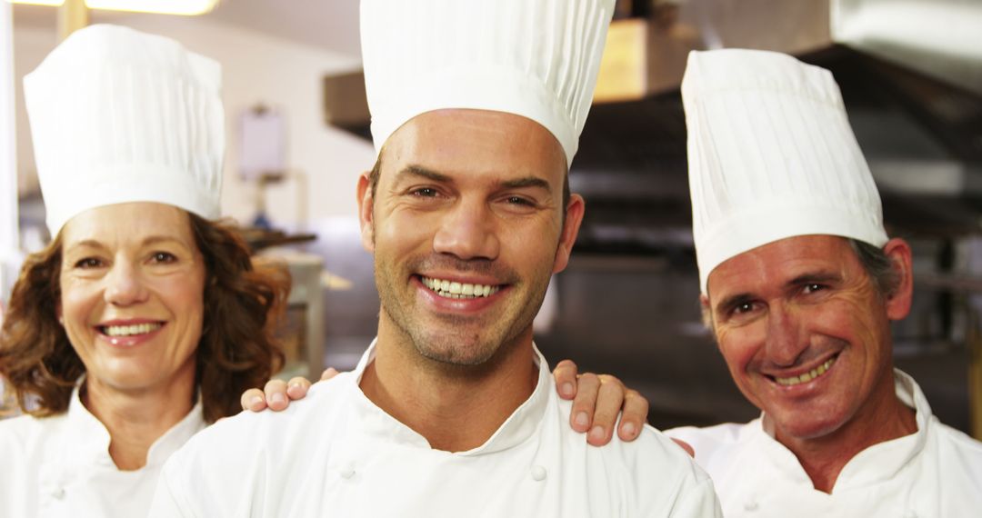 Smiling chefs posing together in commercial kitchen - Free Images, Stock Photos and Pictures on Pikwizard.com