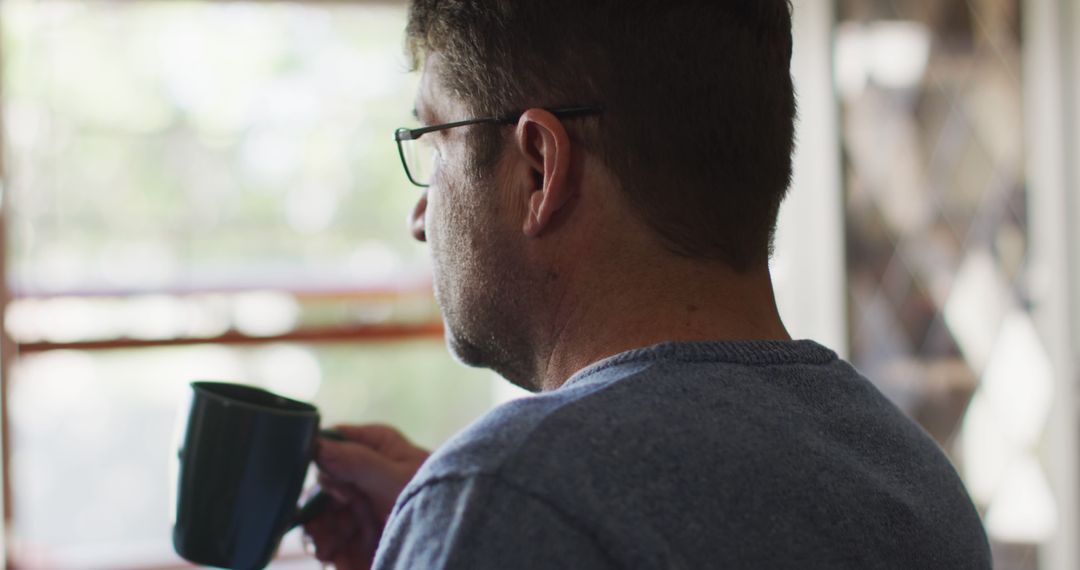 Man Reflecting While Sipping Coffee by Window - Free Images, Stock Photos and Pictures on Pikwizard.com