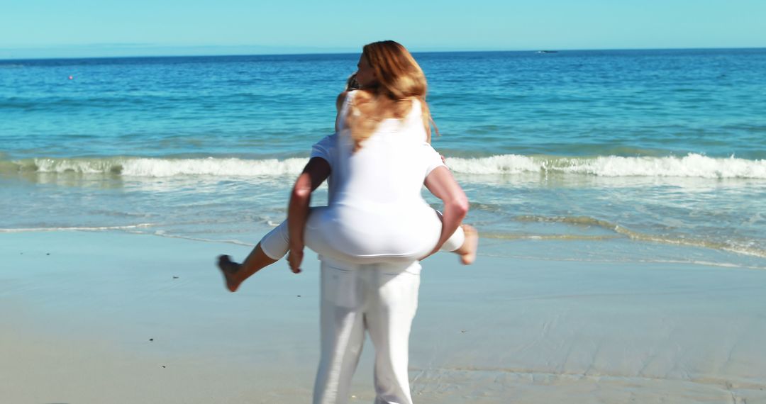 Man giving piggy back ride to woman on beach 4k - Free Images, Stock Photos and Pictures on Pikwizard.com