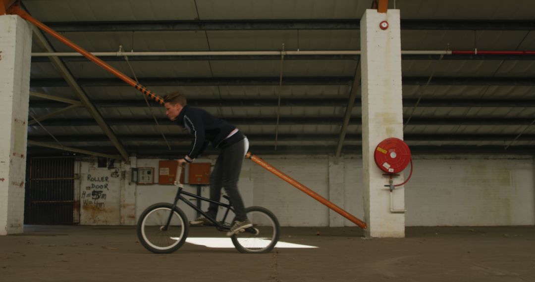 Young Woman Riding BMX Bike in Abandoned Warehouse - Free Images, Stock Photos and Pictures on Pikwizard.com