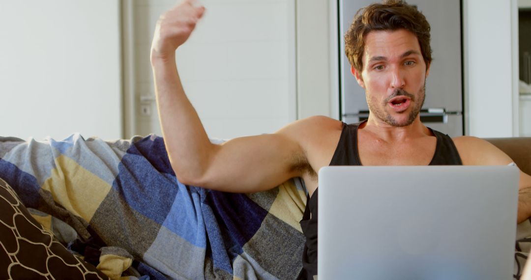 Excited Man Cheering Online Win While Using Laptop on Comfortable Couch - Free Images, Stock Photos and Pictures on Pikwizard.com