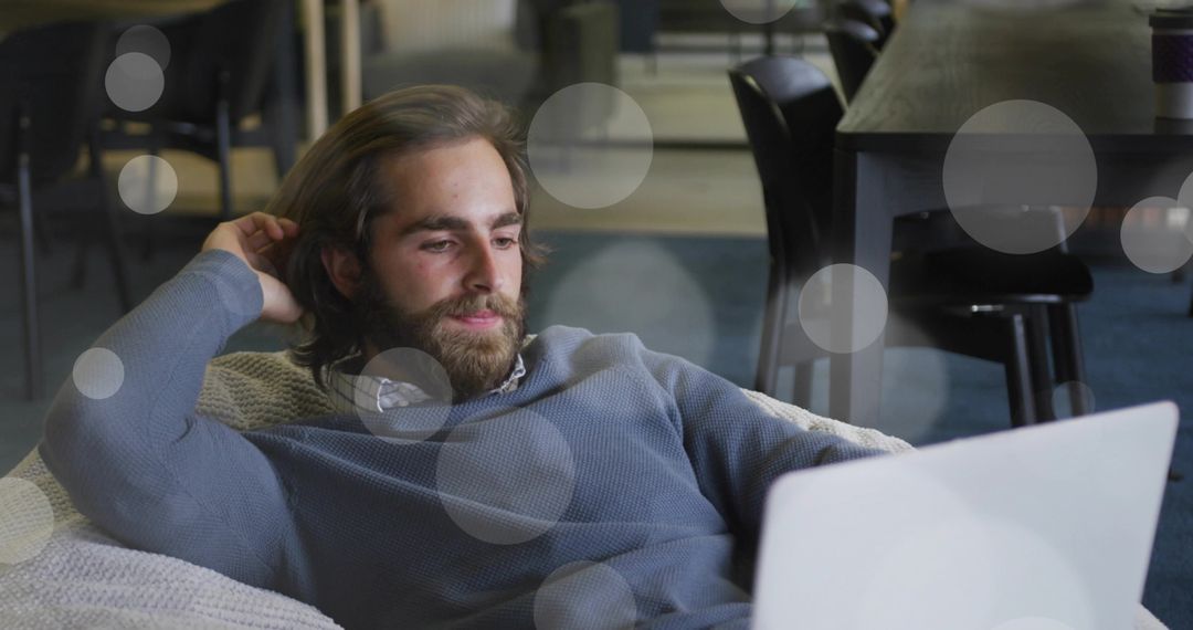 Man Relaxing with Laptop in Comfortable Office Lounge Setting