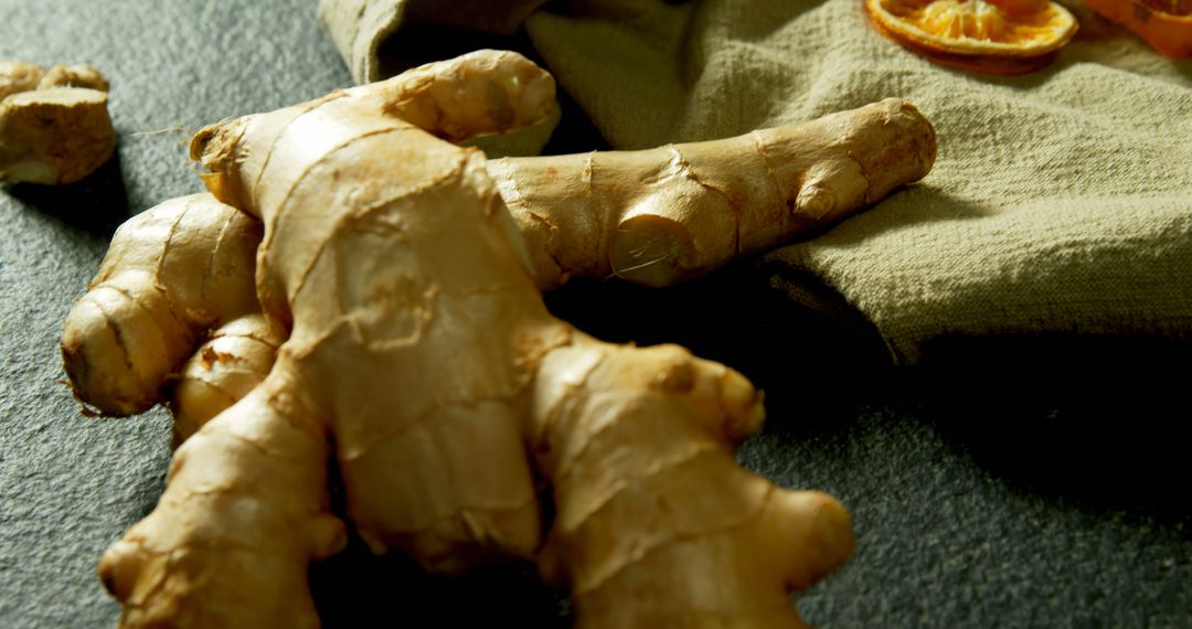 Fresh Ginger Root on Dark Surface Highlighted by Warm Lighting