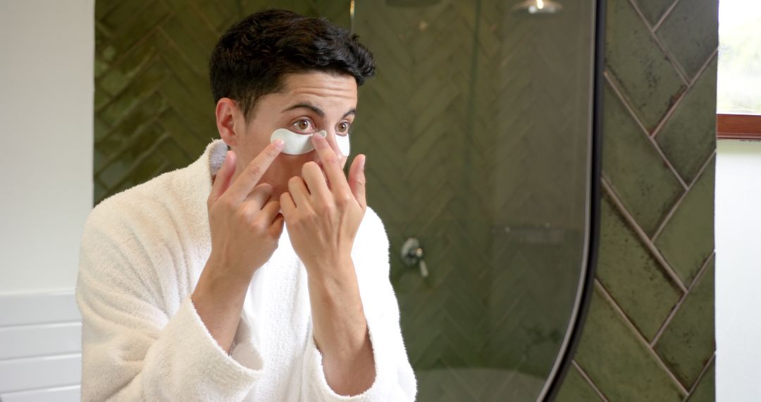 Man Applying Under Eye Masks During Skincare Routine in Bathroom