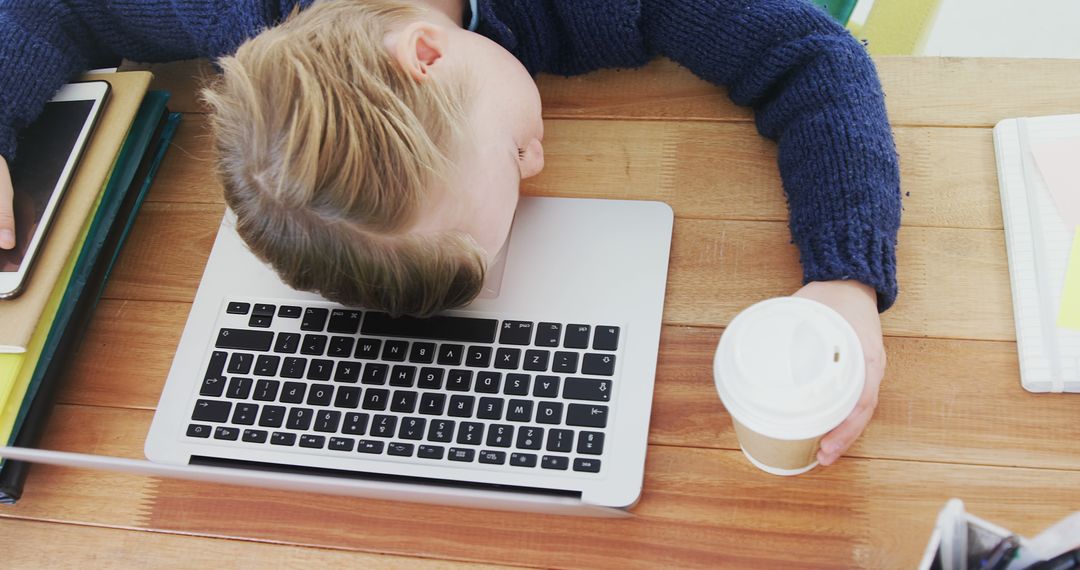 Exhausted Student Sleeping on Laptop While Holding Coffee Cup - Free Images, Stock Photos and Pictures on Pikwizard.com