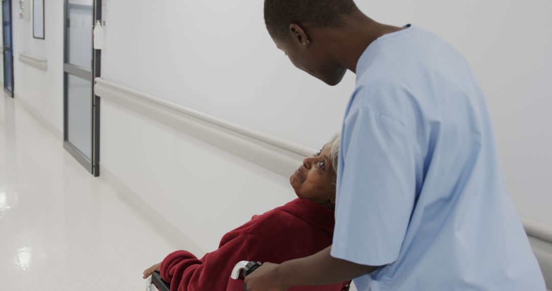 Caregiver Assisting Elderly Woman in Hospital Hallway - Free Images, Stock Photos and Pictures on Pikwizard.com