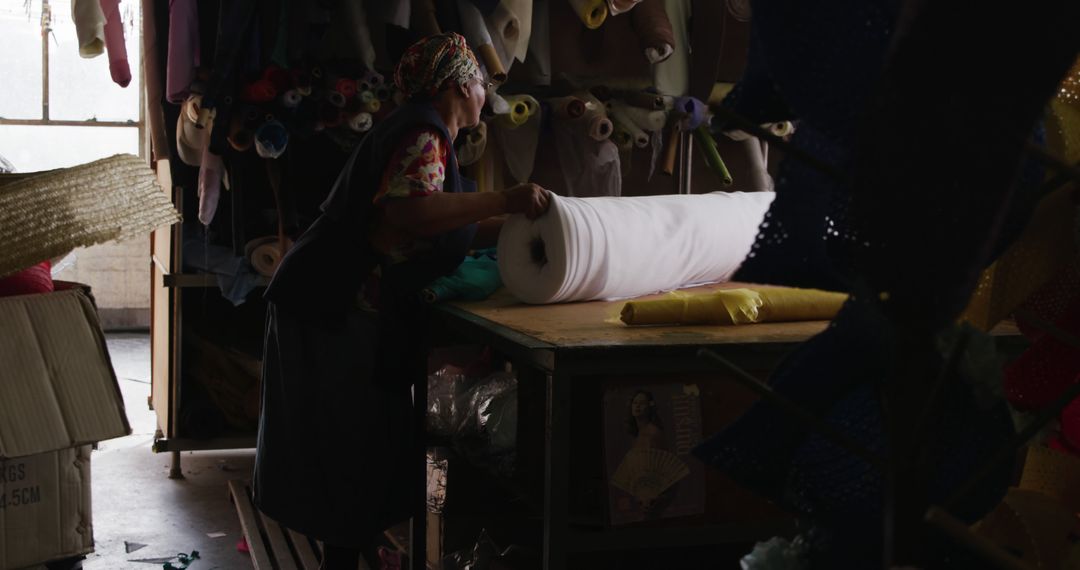 Textile Worker Handling Fabric Roll in Artisan Workshop - Free Images, Stock Photos and Pictures on Pikwizard.com