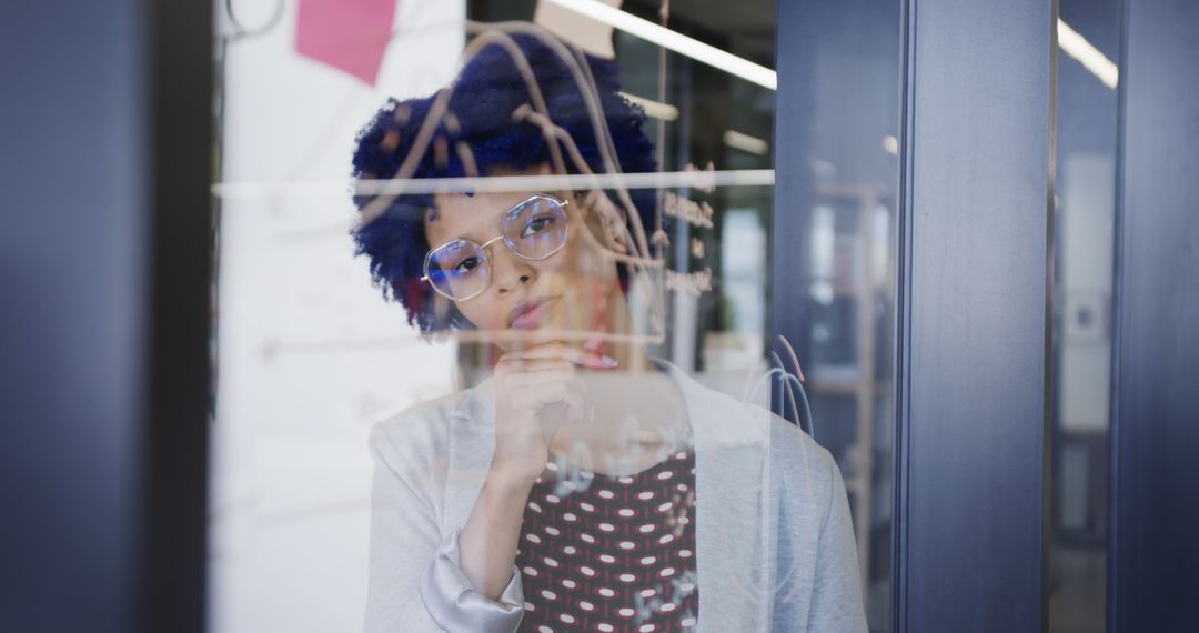 Woman Analyzing Data on Transparent Glass Whiteboard in Office - Free Images, Stock Photos and Pictures on Pikwizard.com