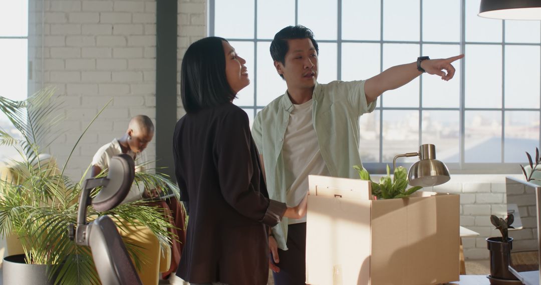 Colleagues Discussing Office Setup in Modern Workspace