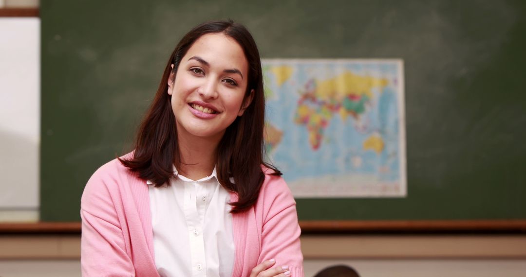 Smiling Teacher Standing in Classroom with Map on Chalkboard - Free Images, Stock Photos and Pictures on Pikwizard.com