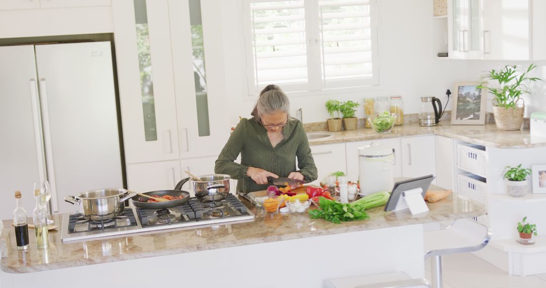 Senior Woman Cooking in Modern Kitchen with Fresh Vegetables - Free Images, Stock Photos and Pictures on Pikwizard.com