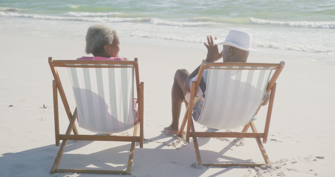 Smiling Senior Couple Enjoying Relaxing Beach Conversation