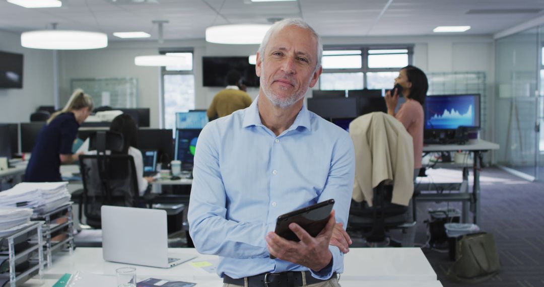 Senior Businessman Holding Tablet in Modern Office Setting - Free Images, Stock Photos and Pictures on Pikwizard.com