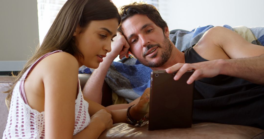 Couple Engaged in Relaxed Digital Browsing on Tablet