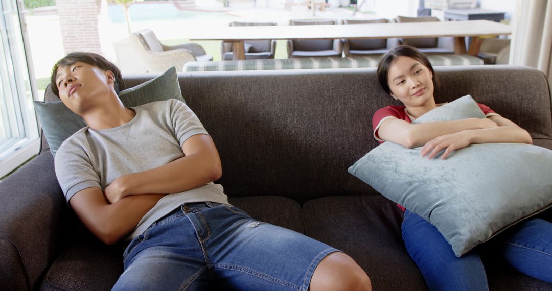 Asian Couple Relaxing on Comfortable Sofa with Cushion