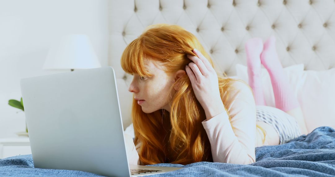 Focused Redhead Young Woman Working on Laptop in Cozy Bedroom - Free Images, Stock Photos and Pictures on Pikwizard.com