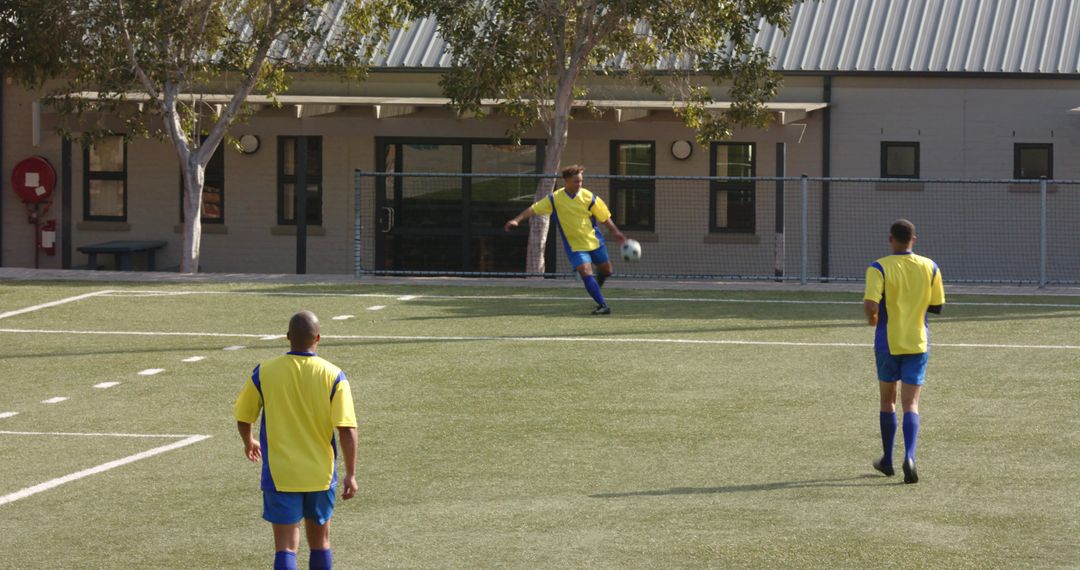 Youth Soccer Team Playing on School Field in Afternoon