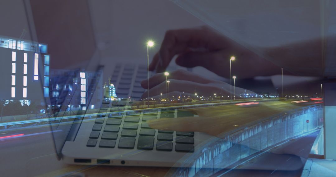 Hands on Laptop with Background of City Traffic at Night