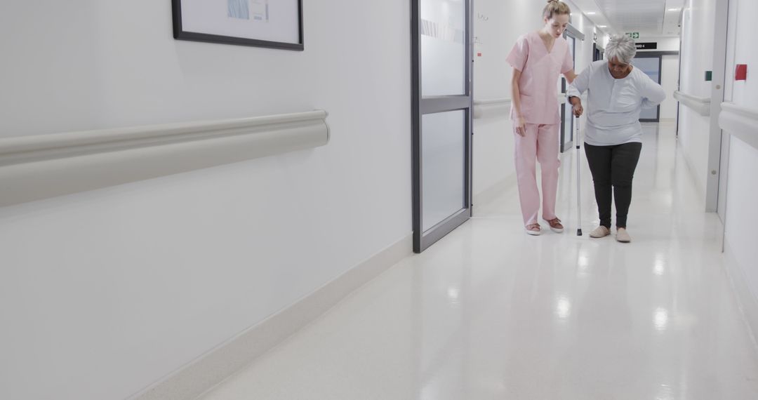 Nurse Assisting Elderly Patient in Hospital Hallway - Free Images, Stock Photos and Pictures on Pikwizard.com