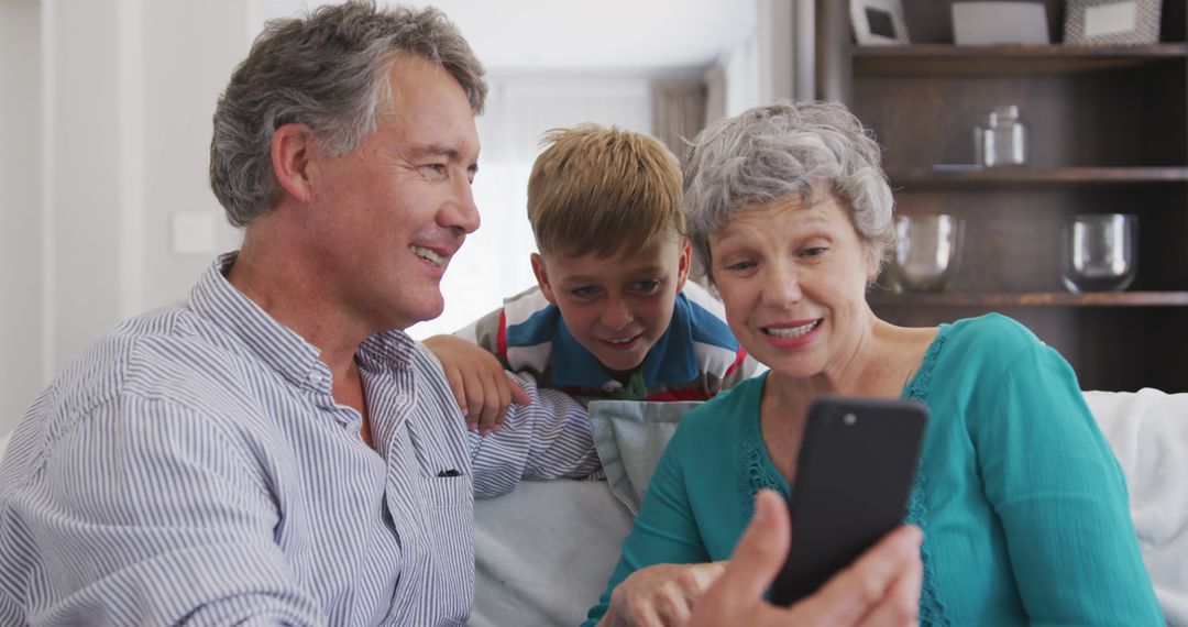 Grandparents and Boy Using Smartphone at Home, Sharing Moment on Couch - Free Images, Stock Photos and Pictures on Pikwizard.com