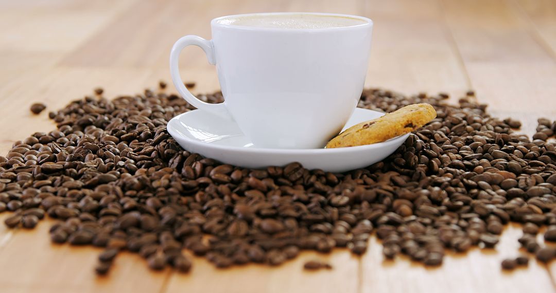 Cup of Coffee with Cookie Surrounded by Coffee Beans - Free Images, Stock Photos and Pictures on Pikwizard.com