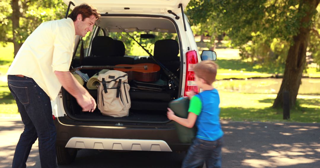 Father and Son Packing Car for Outdoor Adventure in Park - Free Images, Stock Photos and Pictures on Pikwizard.com