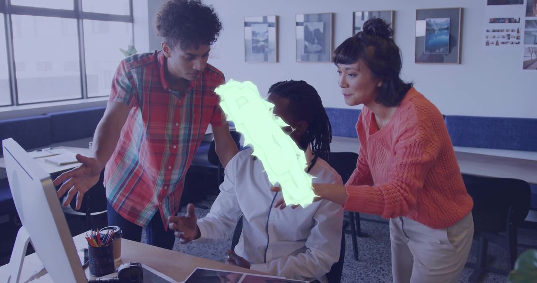 Collaborating team pointing at monitor and brainstorming in modern open-plan creative office