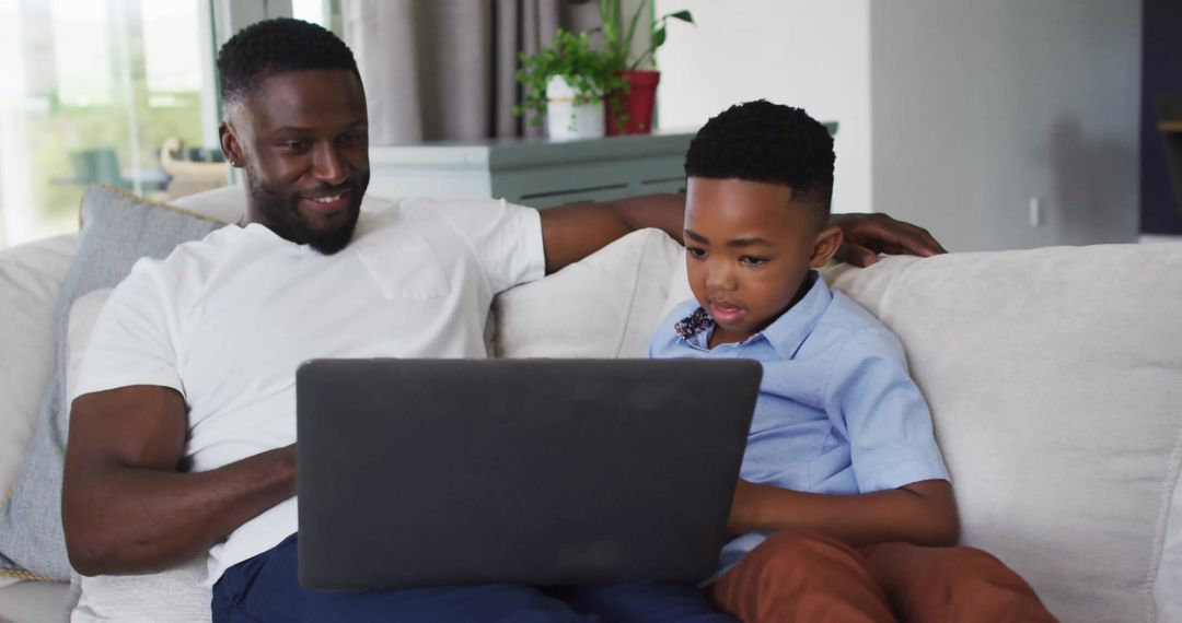 Father and Son Using Laptop in Cozy Living Room for Quality Time