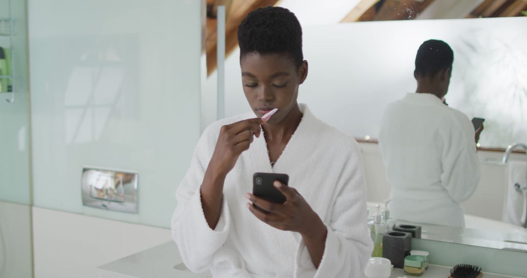 Woman Brushing Teeth While Using Smartphone in Bathroom - Free Images, Stock Photos and Pictures on Pikwizard.com