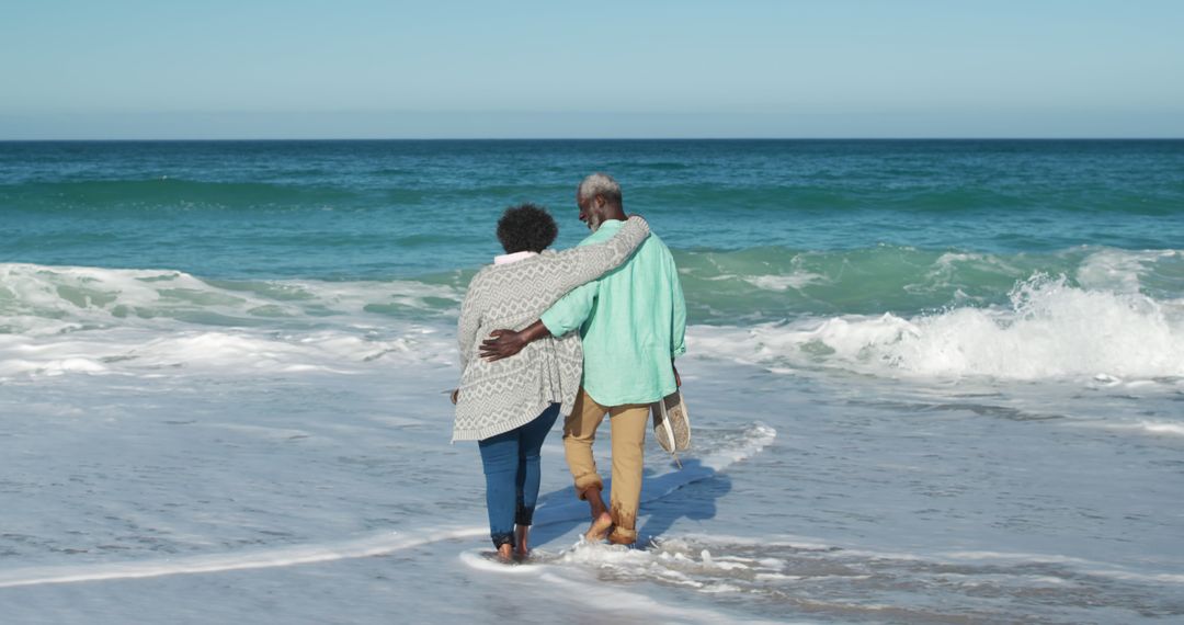 Senior Couple Walking on Beach Embracing - Free Images, Stock Photos and Pictures on Pikwizard.com