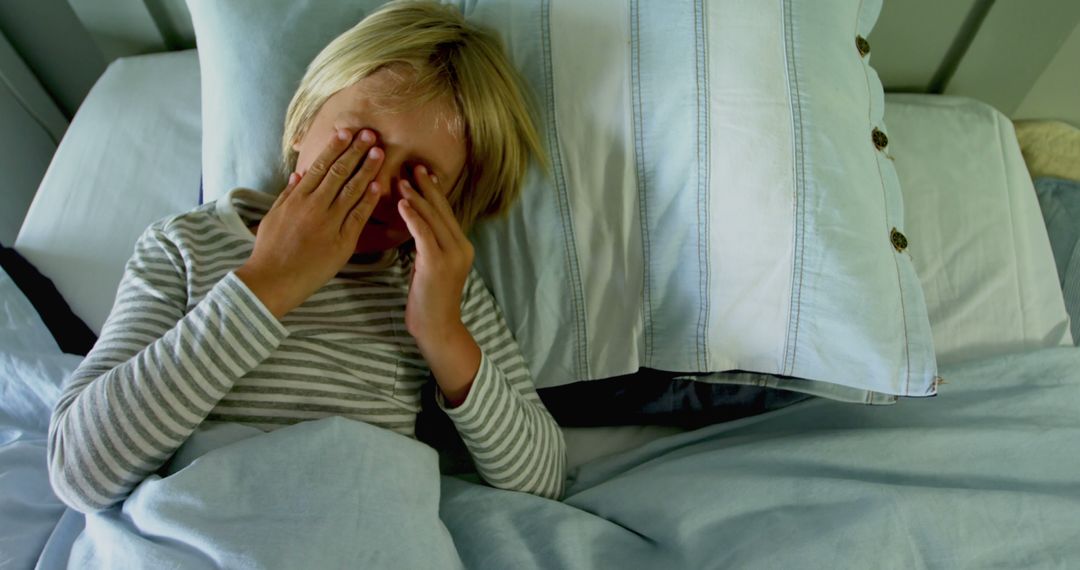 A distressed boy sits in bed, embodying the emotional struggles of children. - Free Images, Stock Photos and Pictures on Pikwizard.com