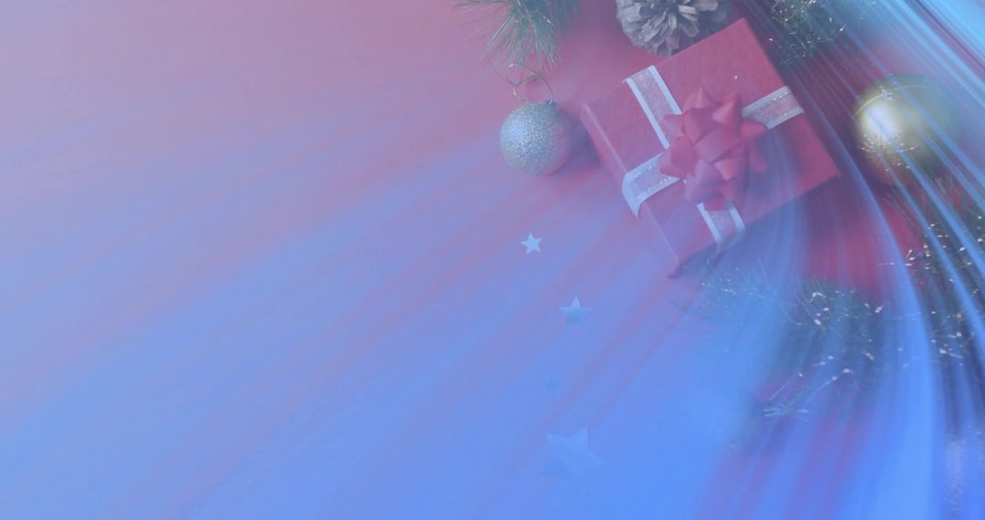 Festive red gift box with white ribbon, baubles and pinecone on blue-red gradient
